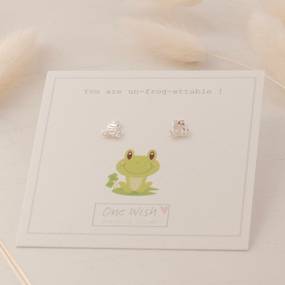 Pair of sterling silver frog stud earrings on gift card that says you are un-frog-ettable