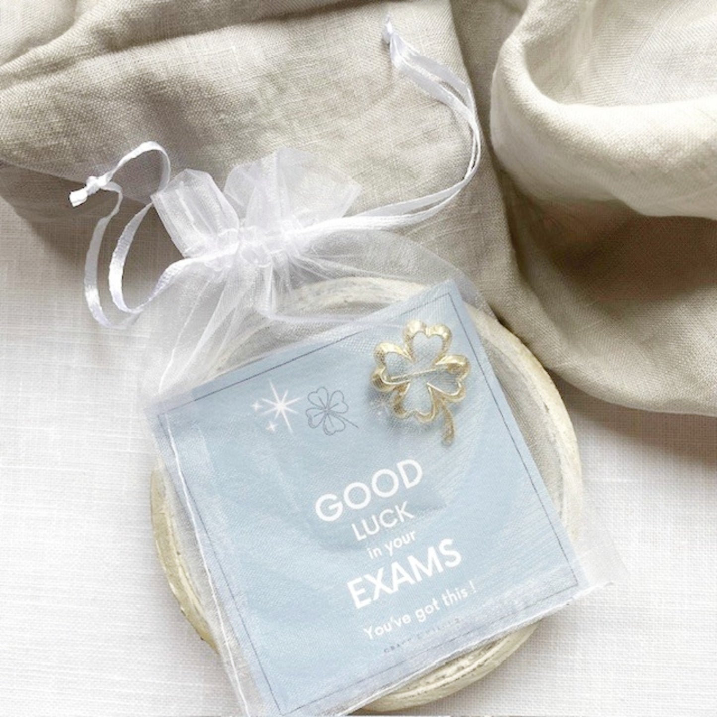 Good luck card with a four-leaf clover charm in a chiffon drawstring pouch