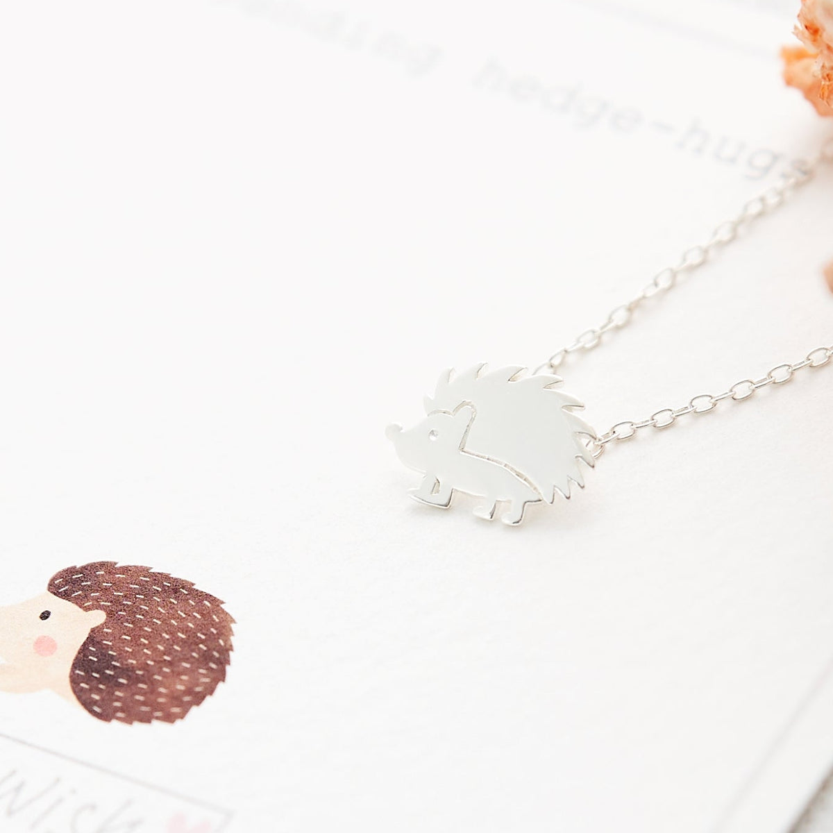 Sterling silver hedgehog pendant necklace displayed on a Sending You Hedgehugs gift card, a thoughtful woodland animal jewellery gift by Grace & Valour.