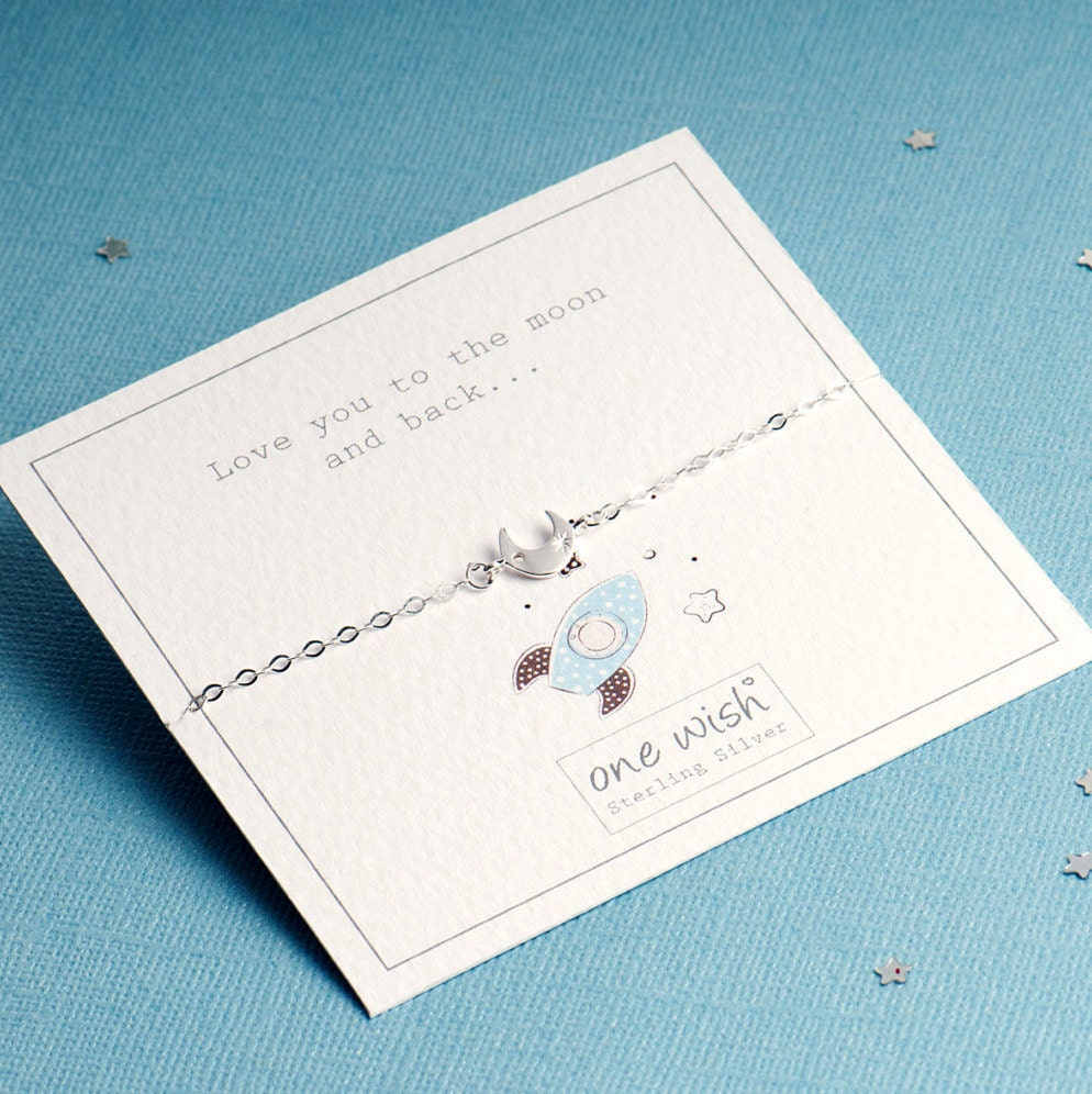 love you to the moon and back giftcard with a graphic of a cute rocket and a silver crescent moon chain link bracelet
