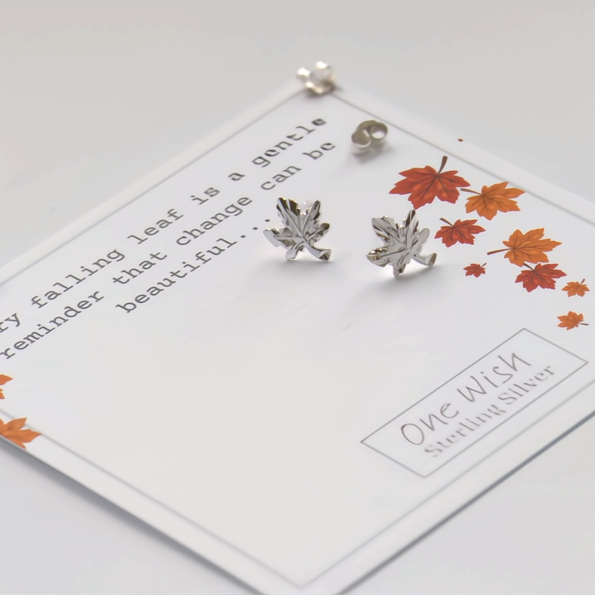 Sterling silver leaf-shaped stud earrings displayed on a white card with autumn leaves and text, including 'One Wish Sterling Silver'.