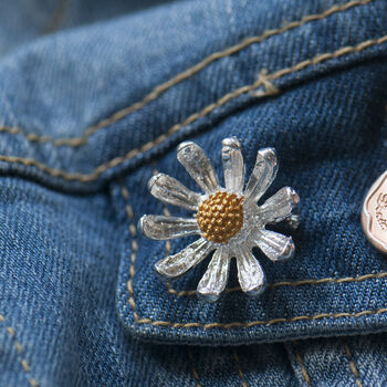 Tiny silver and gold daisy brooch on denim jacket pocket- cute