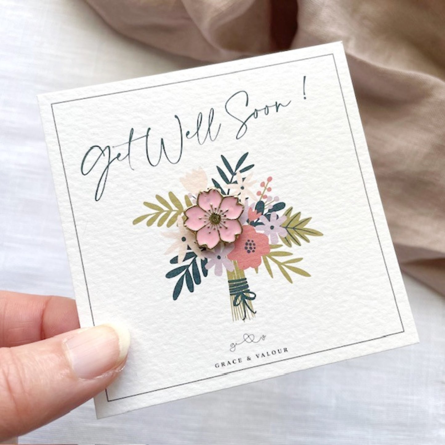 Get well soon card with floral design featuring a pink enamel blossom flower pin in among the bouquet of flowers