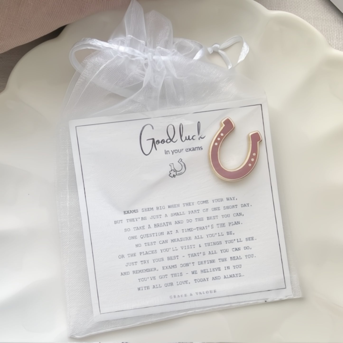 Pink horseshoe enamel pin on a card with a bespoke good luck in your exams gift card.