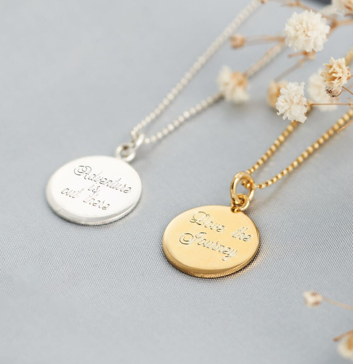 back of the pendants with a quote one says 'Adventure is out there' the other says 'Love the journey'