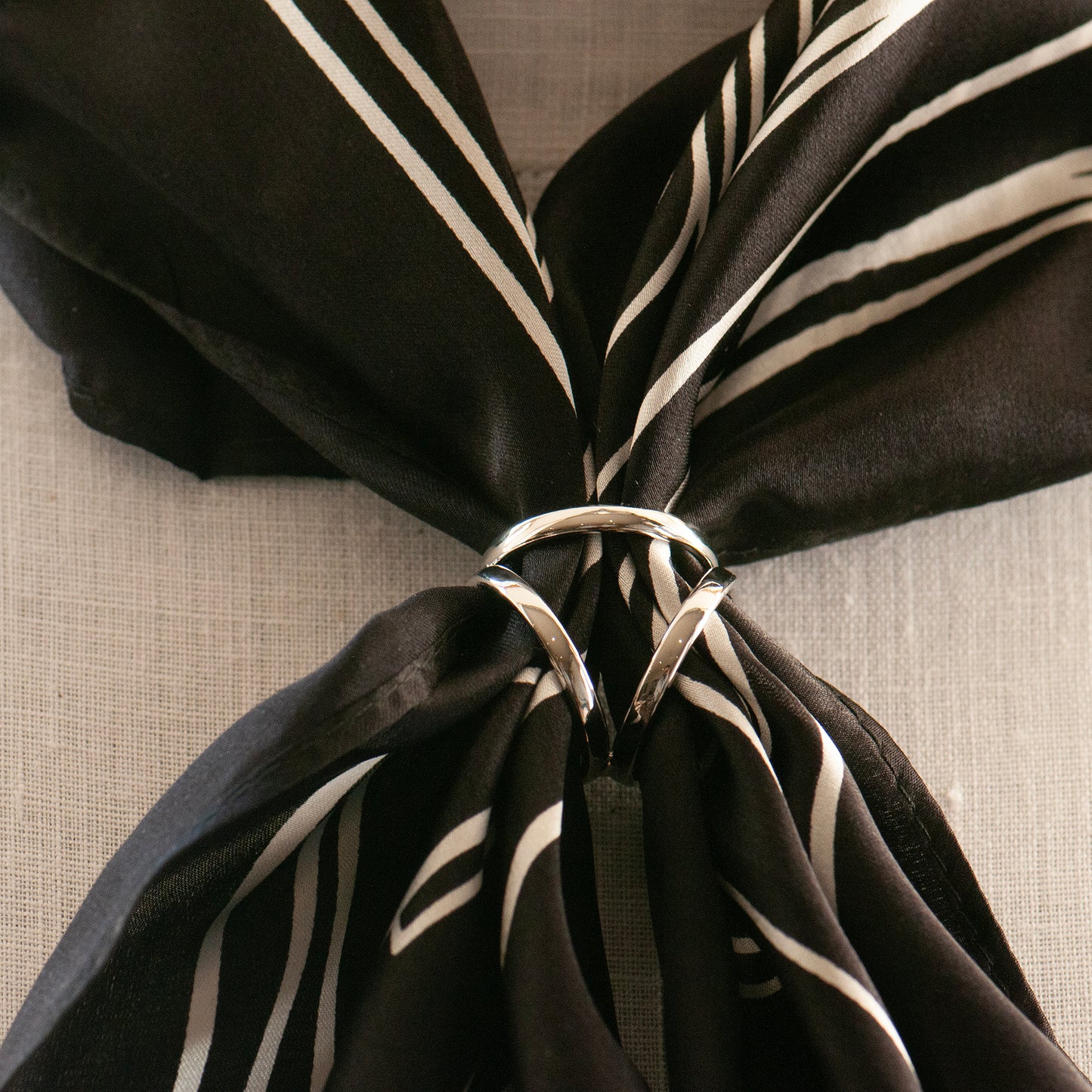 Black and white silk scarf with a silver scarf ring on a model