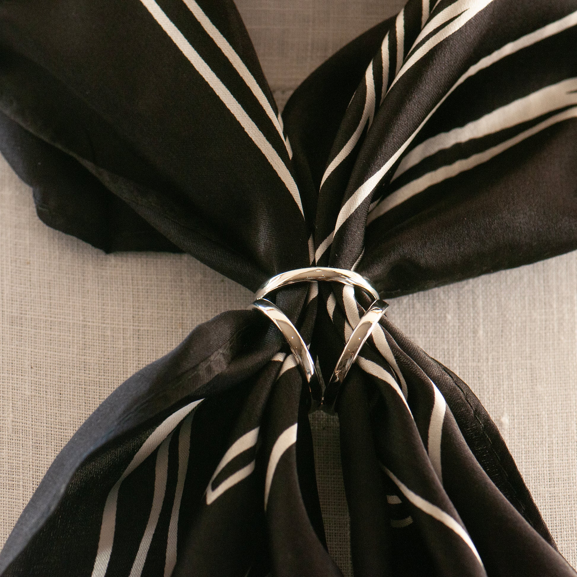 Black and white silk scarf with a silver scarf ring on a model