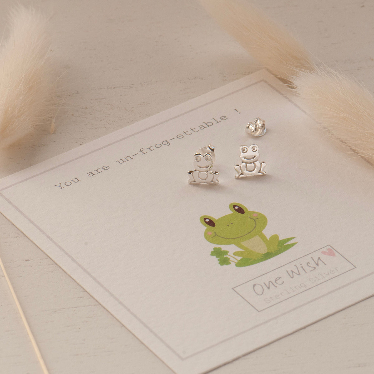 silver frog stud earrings on a frog themed gift card that says you are un-frog-ettable
