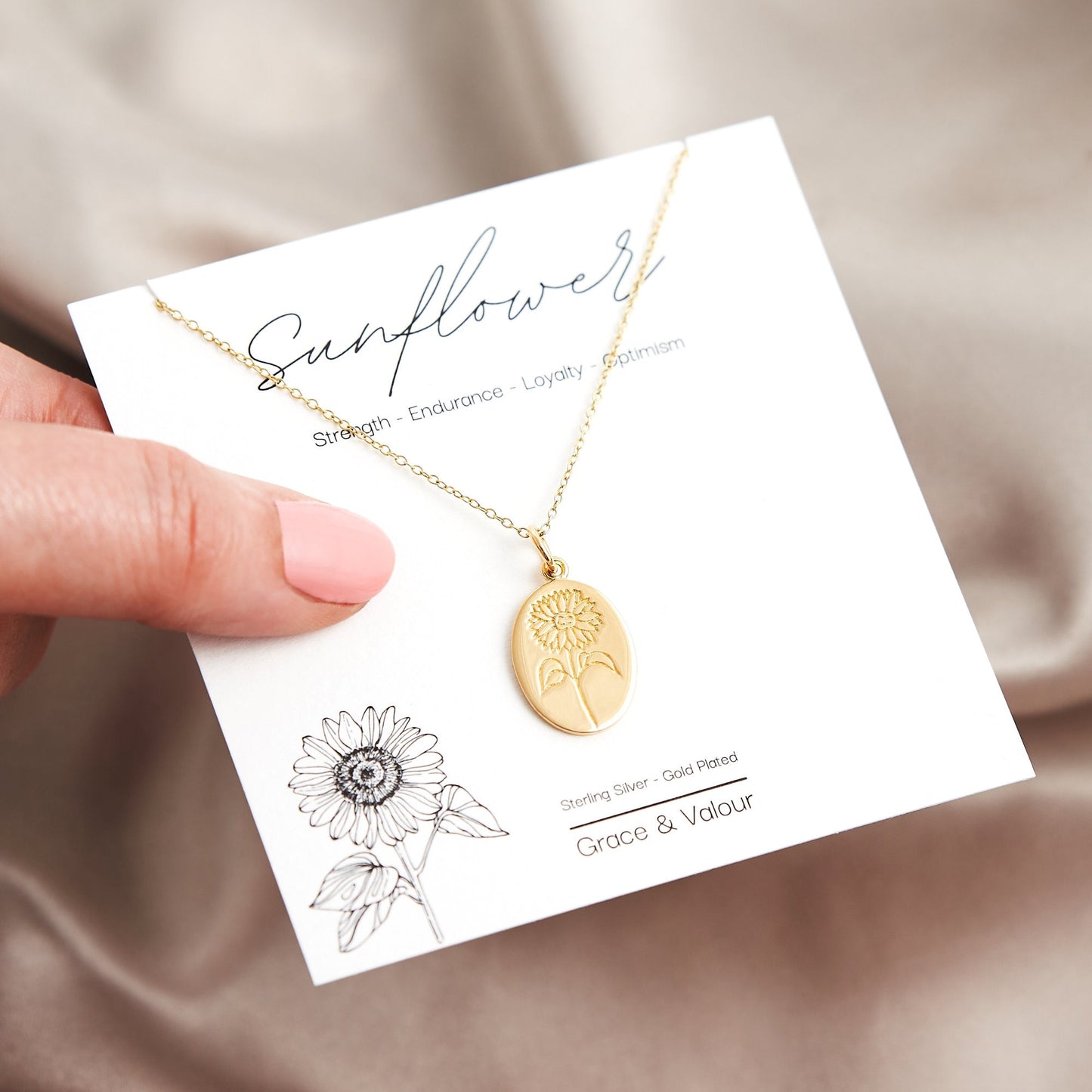engraved sunflower gold oval necklace on gold dainty curb chain on a gift card with a sunflower image and traits of the sunflower according to Florigraphy